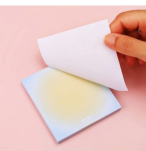 Dettaglio di una mano che stacca un foglietto adesivo sfumato blu-giallo con testo Yolk Lemon Soda