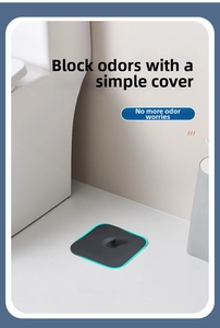 Detailed view of a dark grey silicone drain cover with a handle on bathroom floor