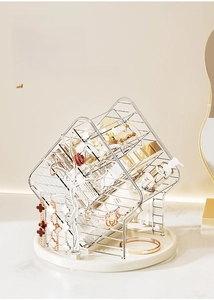 Detailed view of rotating acrylic makeup organizer with silver frame and jewelry tree