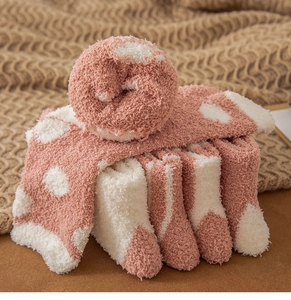 Detailed view of thick coral fleece winter socks with soft pink and white polka dots