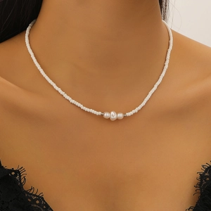 Detail einer weißen Perlenkette mit Barockperlen an weiblichem Hals-Modell