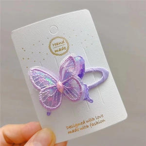 Detailed macro view of purple embroidered butterfly hair clip with colorful sequins