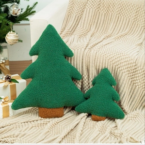 Christmas tree shaped decorative pillows in forest green boucle on a cozy blanket