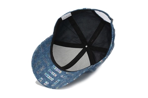 Detail view of denim texture baseball cap with holographic QUEEN printing and inner band