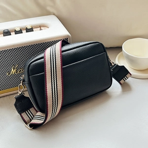 Chic black litchi textured crossbody bag with a stylish wide striped shoulder strap