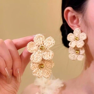 Detailed view of handmade woven double cream flower earrings in Bohemian summer style
