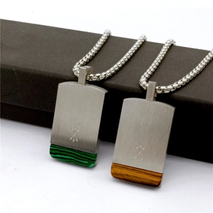 Macro shot of men's square pendant necklace with green malachite and brown tiger eye stone
