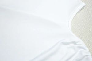 Détail d'un crop top blanc en maille côtelée avec fronces latérales et col rond élégant
