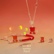Detail view of coin-themed jewelry set with red rope bracelet and golden necklace