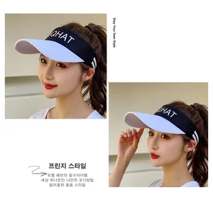 Detail of a black and white QHAT visor hat featuring side stripes and sporty lettering