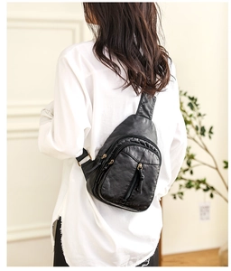 Rear view of a model wearing the black soft PU leather chest bag with gold zippers