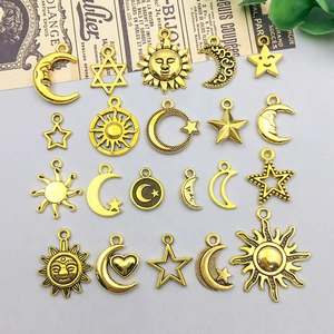 Macro view of vintage gold celestial charms featuring sun, moon, and star designs for DIY