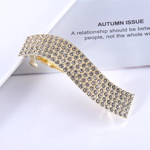 Elegant gold wavy hair clip encrusted with sparkling rhinestones on minimalist card