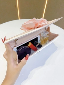 Pink pleated evening clutch bag with elegant fabric flower detail, interior capacity view.