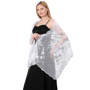 Detailed view of a white bridal shawl featuring intricate floral embroidery and silver sequins