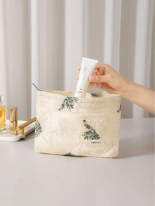 Beige cotton linen makeup bag with green floral embroidery and metal zipper closure