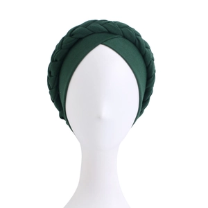 Detail of dark green braided turban hat showing elastic knitted texture and twist knot