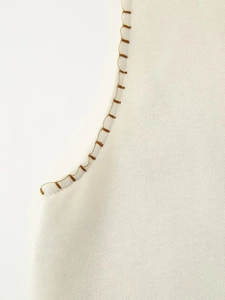 Close-up of off-white knit fabric featuring detailed brown stitching on the collar edge