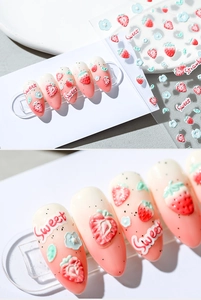 Detail of 3D embossed nail stickers featuring pink strawberry designs and Sweet text