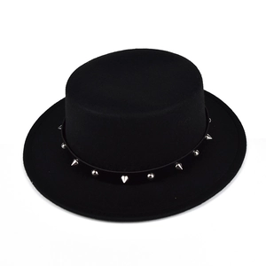 Close-up of black felt flat top hat with silver studs and cone spikes on the band