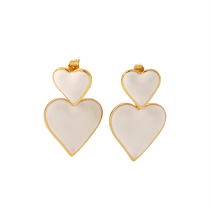 Detailed macro of white and gold double heart drop earrings with polished 18k plating