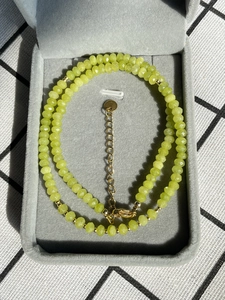 Detailansicht der facettierten limettengrünen Kristallperlen mit goldenem Karabinerverschluss