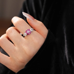 Close-up of a silver floral ring with pink stones and zircons on a model's finger