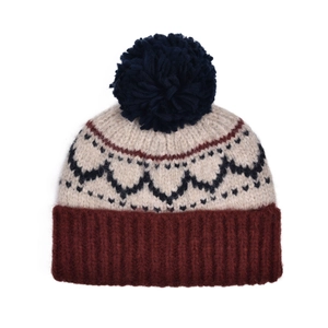 Détail du bonnet en tricot vintage montrant les vagues jacquard et le pompon