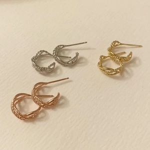 Detailed view of silver, gold, and rose gold twisted rope texture hoop earrings