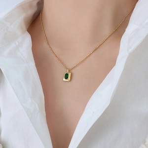 Elegant gold bead chain necklace with rectangular green gemstone pendant on model