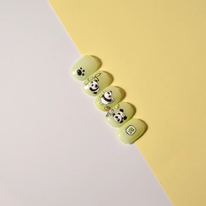 Detailed view of 5D panda and bamboo embossed nail stickers on light green nails