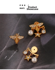 Detailed close-up of golden bee earrings with zircons, stars and faux pearl pendants