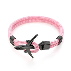 Dettaglio del bracciale in corda intrecciata rosa con chiusura a forma di aereo nero