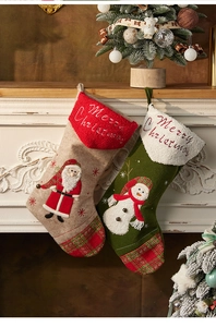 Detail of Christmas stockings with Santa and Snowman hanging on a festive fireplace