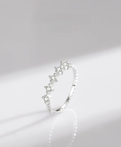 Dettaglio anello in argento 925 con cinque zirconi e raffinata trama a microsfere