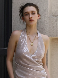 Detail of 18K gold plated stainless steel star coin necklace worn by a model