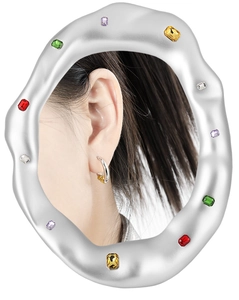 Close-up of geometric C-shaped two-tone earrings on model ear with creative artistic frame