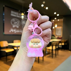 Gros plan sur un porte-clés rose en acrylique avec paillettes et figurine de dessin animé