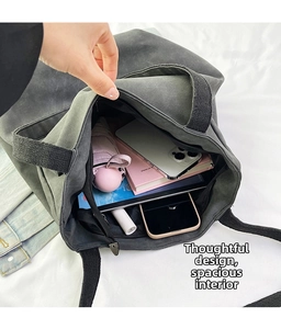 Detail view of the spacious inner compartment of the canvas tote bag with personal items