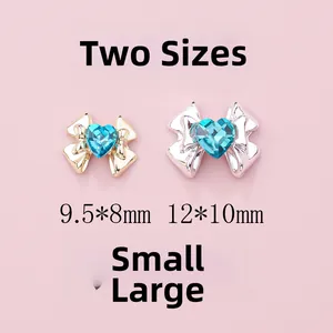Detail of bow-shaped nail art charms with sea blue heart rhinestones in two sizes