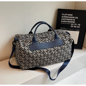 Sac de voyage bleu marine élégant avec motif monogramme et poignées en cuir chic