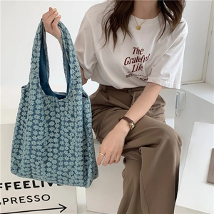 Detail of light blue floral lace tote bag featuring intricate jacquard texture design