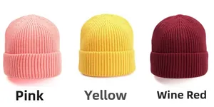 Detailed knit texture of solid color winter beanies in pink, yellow and wine red colors