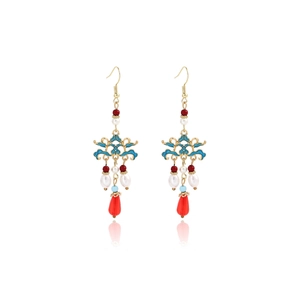 Macro detail of Chinese style gold earrings with blue enamel and red teardrop pendants