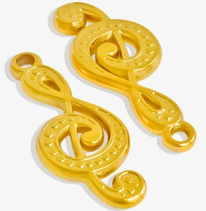 Detailed view of two gold treble clef music note pendants with dotted metal texture
