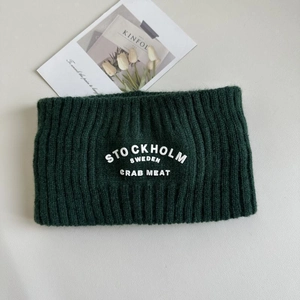 Detail eines dunkelgrünen Strick-Stirnbands mit weißer Stockholm-Schweden-Stickerei