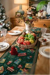 Detailed view of dark green Christmas table runner with festive jacquard woven patterns
