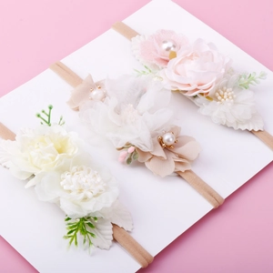 Three-piece baby floral headbands with fabric roses and pearls on a white display card