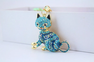 Close-up of sparkling blue rhinestones on a golden lucky cat metal keychain
