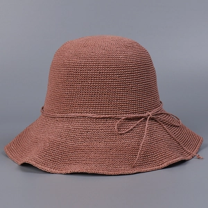 Macro detail of hand-crocheted caramel straw hat texture with fine bow decoration